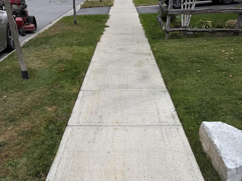 Grass neatly trimmed and edged along both sides of a sidewalk